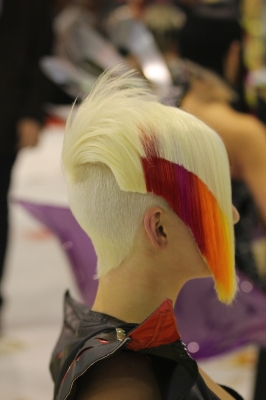 Krótkie blond włosy z marchewkowo - rudym pasmem, wygolonym tyłem i asymetrycznym bokiem